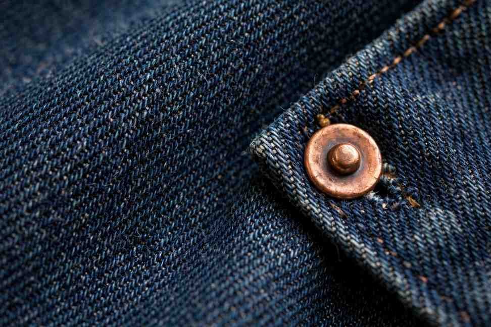 Close-up of premium raw denim fabric texture and rivets